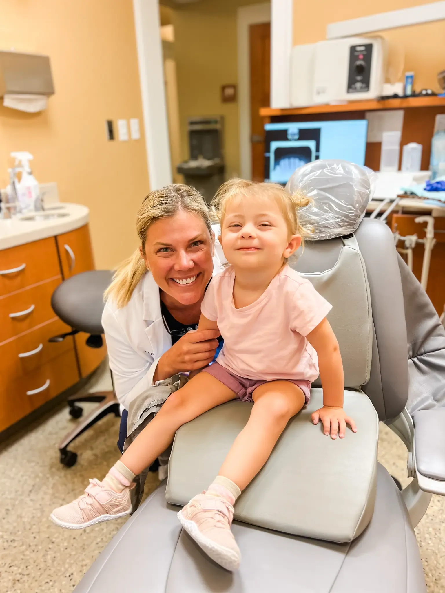 A young patient sitting comfortably with a Grandville Dental clinician in a treatment chair