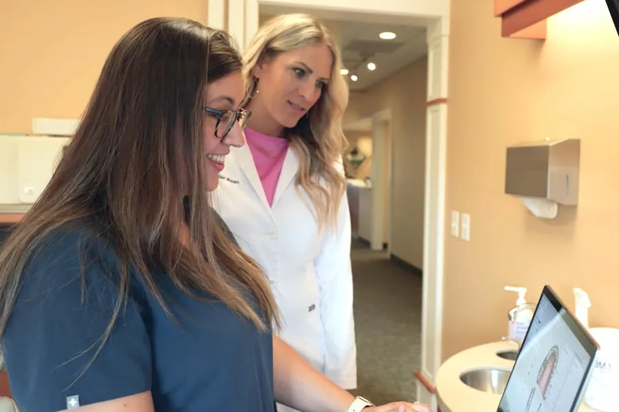 A Grandville Dental team member and clinician reviewing dental images together during a preventive care visit